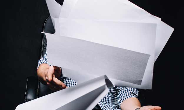 Man Throwing Papers in the Air as There is Too Much Paper Clutter.