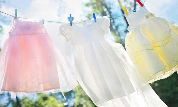 Clean Baby Clothes Hanging in Sunshine.
