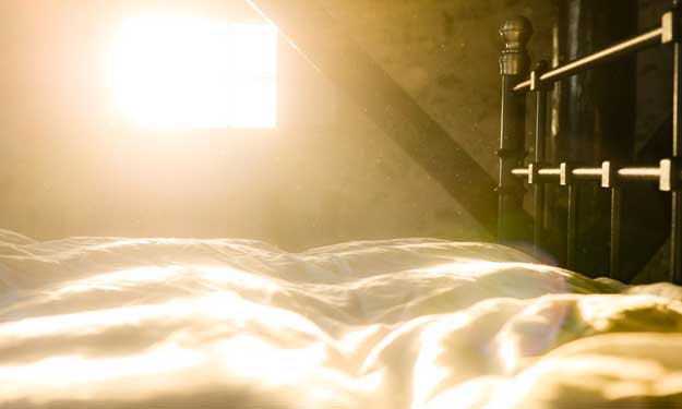 Sun Streaming Through Window Showing Dusty Bedroom.