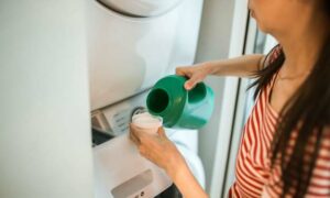 Woman Adding Laundry Detergent to Washing Machine, How to Use Efficiently.