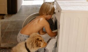 Young Boy Learning How to Wash Laundry.
